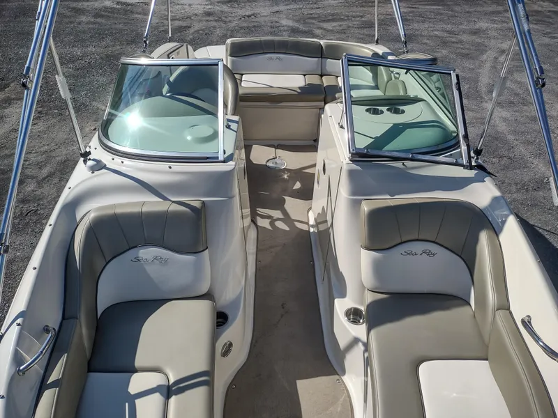 Slide: The Image of 2006 Sea Ray 200 Sundeck boat interior with beige seating and dual windshields. - 8