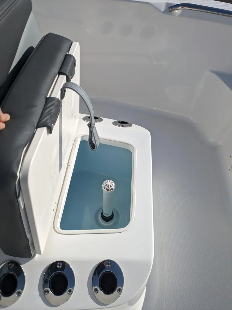 Slide: The Image of 2025 Robalo R160 boat livewell with cushioned seat and rod holders. - 10