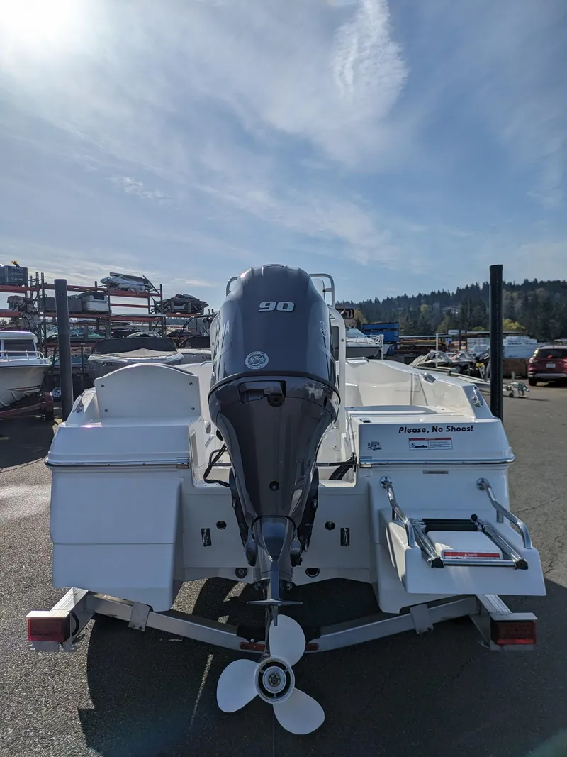 Slide: The Image of 2025 Robalo R160 boat with 90 HP engine, parked outdoors under a clear sky. - 3