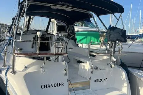 Slide: The Image of 2006 Hunter 44 Deck Salon yacht docked, featuring dual steering wheels and a navy canopy. - 13