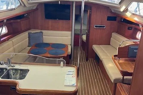 Slide: The Image of Interior of 2006 Hunter 44 Deck Salon with seating, table, and kitchenette. - 21