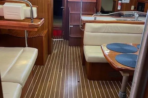 Slide: The Image of Interior of 2006 Hunter 44 Deck Salon with wood flooring and beige seating. - 27