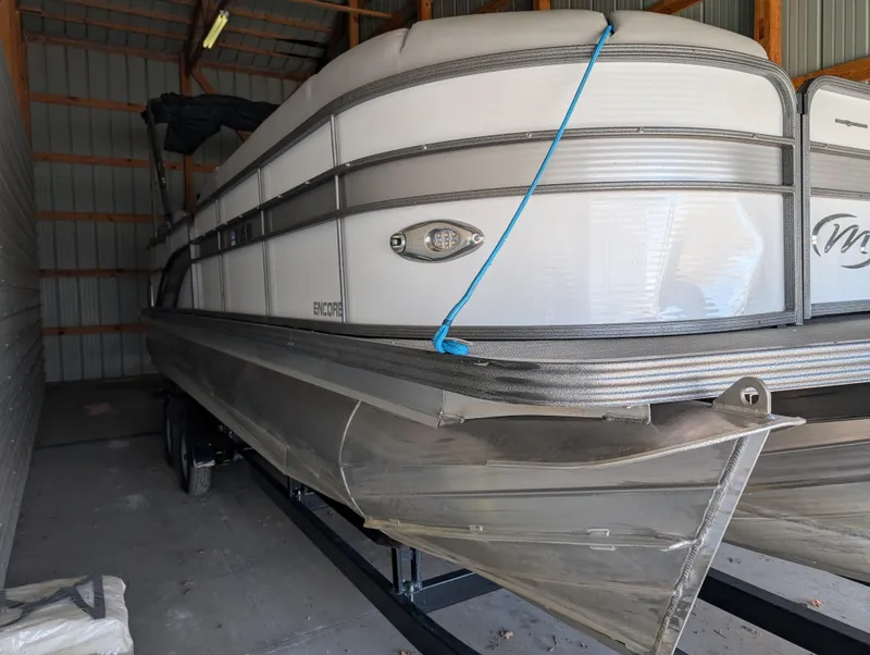 Slide: The Image of 2019 Manitou 25 Encore SE pontoon boat stored in a shed. - 11