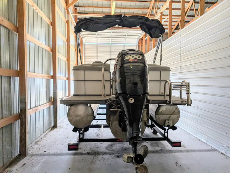 Slide: The Image of 2019 Manitou 25 Encore SE pontoon boat stored in a shed. - 13