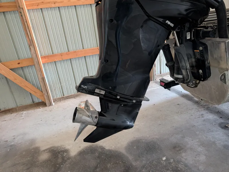 Slide: The Image of 2019 Manitou 25 Encore SE boat motor in a garage setting. - 16