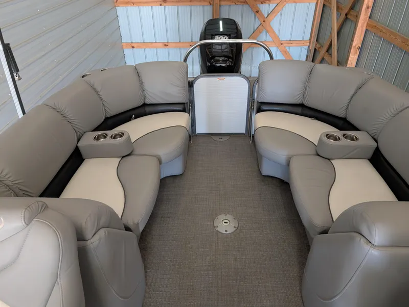 Slide: The Image of 2019 Manitou 25 Encore SE pontoon boat interior with plush seating and cup holders. - 19