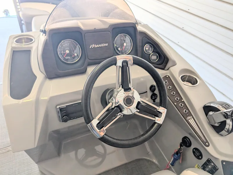 Slide: The Image of Steering console of a 2019 Manitou 25 Encore SE boat with gauges and controls. - 24