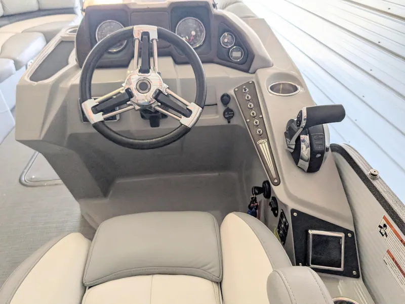 Slide: The Image of 2019 Manitou 25 Encore SE boat dashboard with steering wheel and controls. - 26