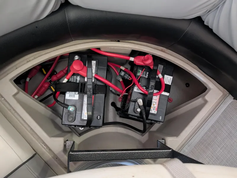 Slide: The Image of 2019 Manitou 25 Encore SE boat battery compartment with connected cables. - 27