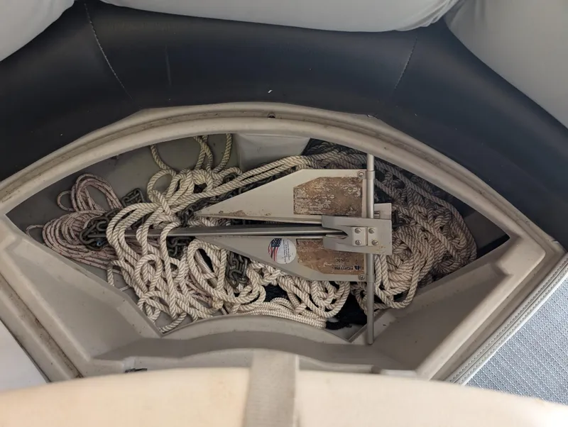 Slide: The Image of Anchor and ropes stored in a 2019 Manitou 25 Encore SE boat compartment. - 30