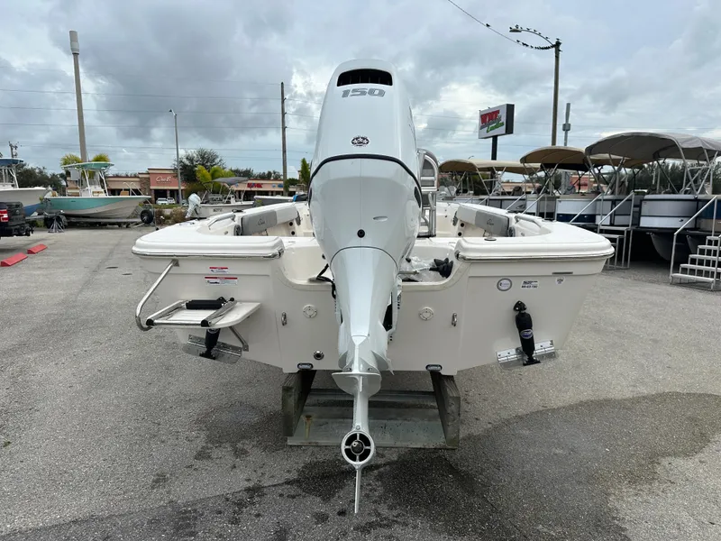 Slide: The Image of 2025 Sea Chaser 21 LX boat with outboard motor, parked outdoors. - 14