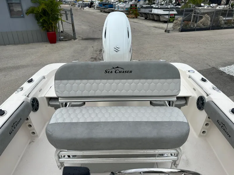 Slide: The Image of 2025 Sea Chaser 21 LX boat interior with cushioned seating and outboard motor. - 23