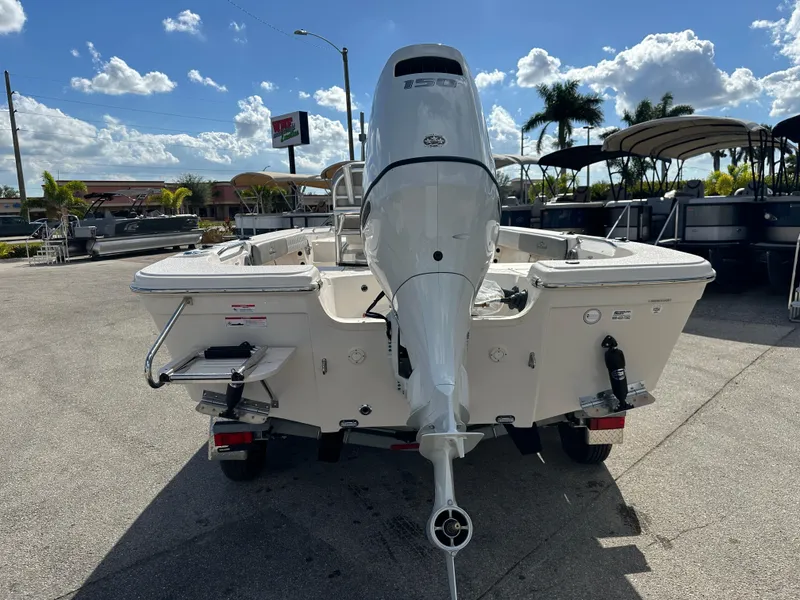 Slide: The Image of 2025 Sea Chaser 21 LX boat with outboard motor, parked outdoors under a sunny sky. - 7