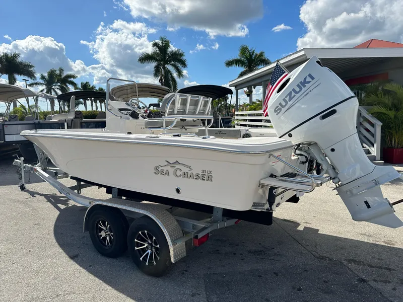 Slide: The Image of 2025 Sea Chaser 21 LX boat with Suzuki engine on trailer, parked outdoors. - 9