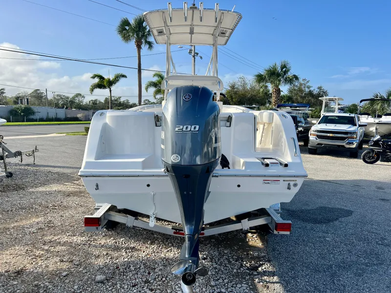 Slide: The Image of 2023 Cobia 220 CC boat with Yamaha 200 engine, parked outdoors. - 6