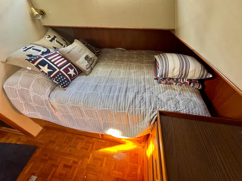 Slide: The Image of Cozy cabin bed in 1979 Grand Banks Classic boat with nautical-themed pillows. - 28