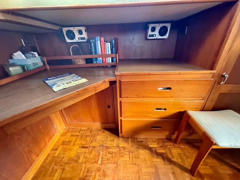 Slide: The Image of 1979 Grand Banks Classic interior with wooden desk, books, and drawers. - 30