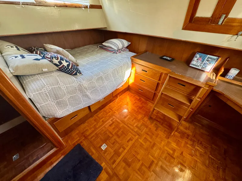 Slide: The Image of Cozy cabin interior of 1979 Grand Banks Classic with bed, wooden desk, and parquet flooring. - 33