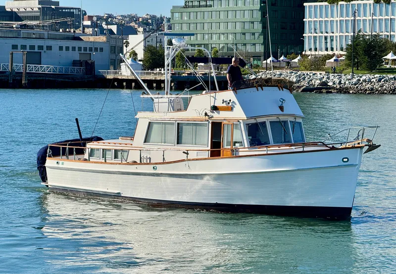 The Image of 1979 Grand Banks Classic boat cruising in urban harbor setting. - 0