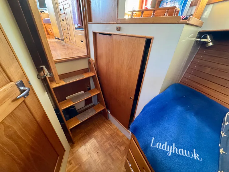 Slide: The Image of 1979 Grand Banks Classic interior with wooden stairs and cozy sleeping area. - 11