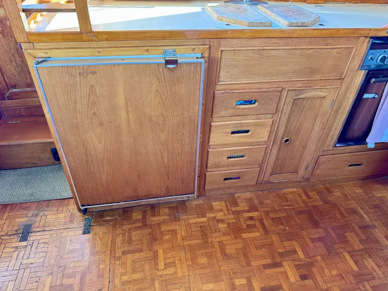 Slide: The Image of 1979 Grand Banks Classic wooden kitchen interior with parquet flooring and cabinetry. - 15