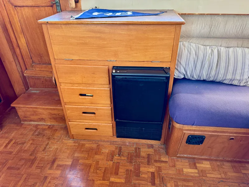 Slide: The Image of 1979 Grand Banks Classic interior with wooden cabinetry and compact refrigerator. - 16