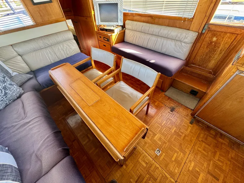 Slide: The Image of 1979 Grand Banks Classic yacht interior with wooden furniture and seating area. - 26