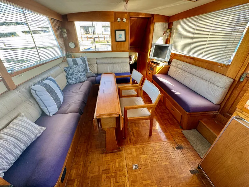 Slide: The Image of 1979 Grand Banks Classic yacht interior with cozy seating and wooden furnishings. - 4