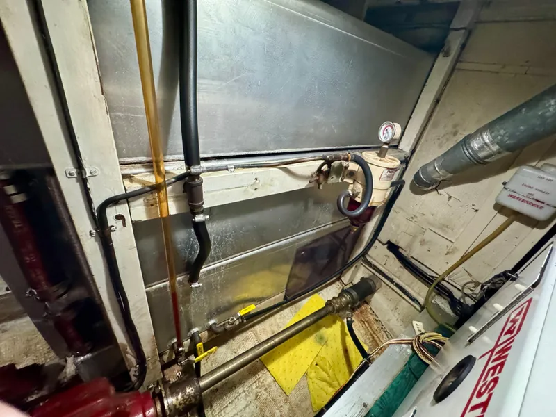 Slide: The Image of Engine room of 1979 Grand Banks Classic boat with visible pipes and machinery. - 40