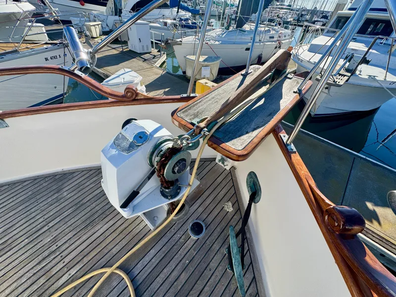 Slide: The Image of 1979 Grand Banks Classic yacht deck with anchor winch and wooden railings in marina. - 47