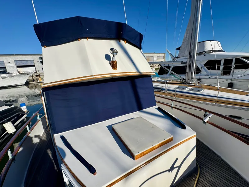 Slide: The Image of 1979 Grand Banks Classic yacht with blue canvas cover, docked at marina. - 49