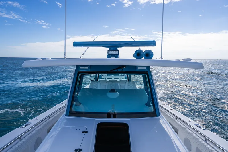 Slide: The Image of 2025 HCB 53 Sueños boat cruising on open sea under clear blue sky. - 28