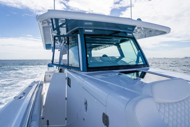 Slide: The Image of HCB 53 Sueños 2025 boat cruising on open water under a clear sky. - 29