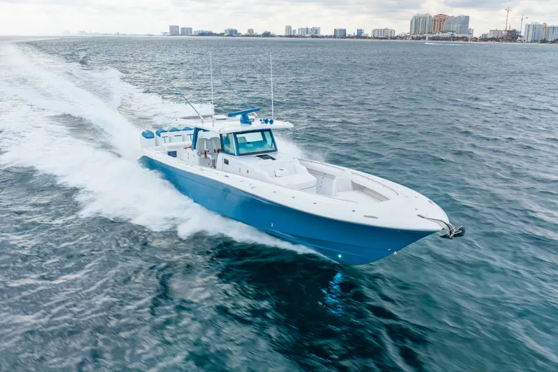 Slide: The Image of 2025 HCB 53 Sueños boat cruising on open water, city skyline in background. - 37