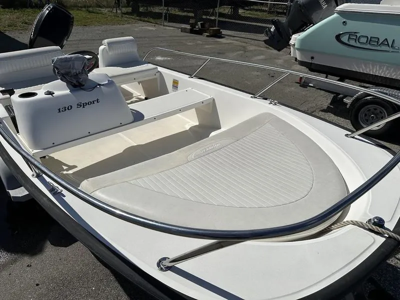 Slide: The Image of 2005 Boston Whaler 130 Super Sport boat, white interior, parked on a trailer. - 10