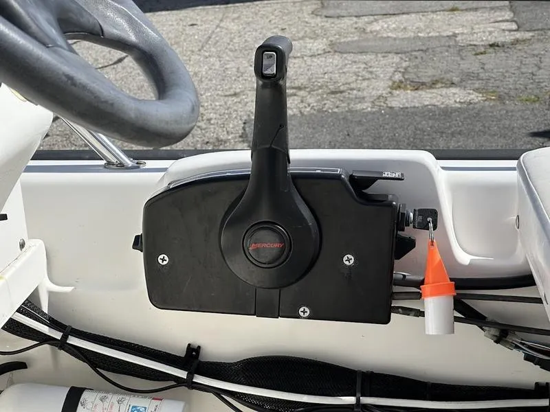 Slide: The Image of Boston Whaler 130 Super Sport 2005 throttle control and steering wheel detail. - 12
