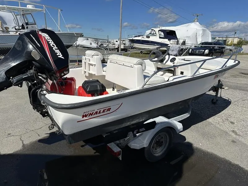 Slide: The Image of 2005 Boston Whaler 130 Super Sport boat on trailer with Mercury outboard motor. - 4