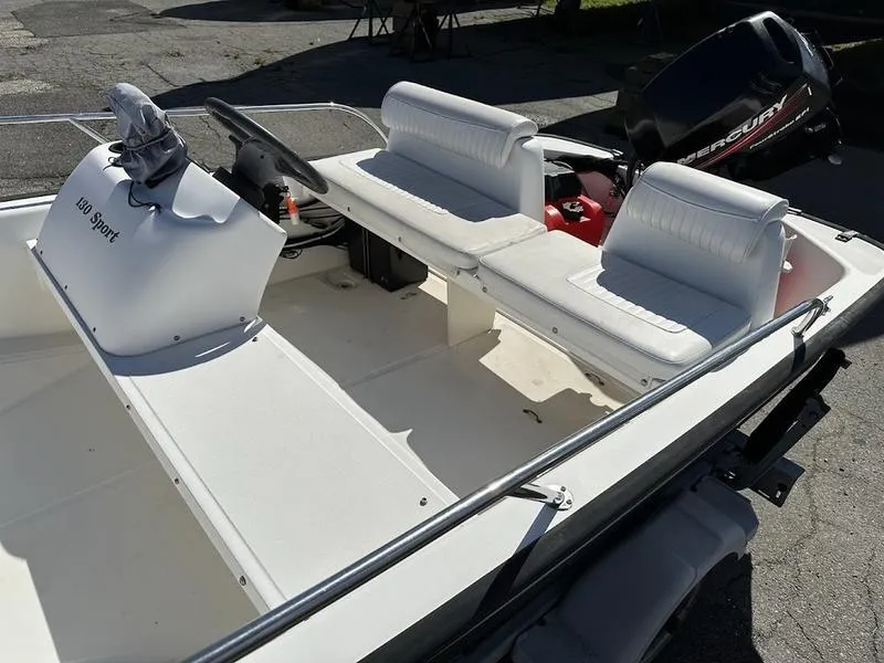 Slide: The Image of 2005 Boston Whaler 130 Super Sport boat interior with white seating and steering console. - 5