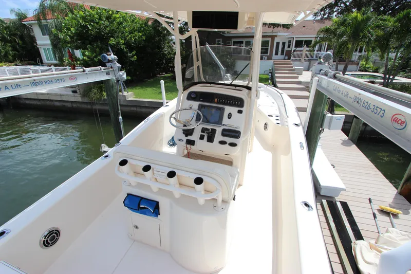 Slide: The Image of 2015 Grady-White 251 Coastal Explorer boat docked, featuring a spacious helm and modern controls. - 12