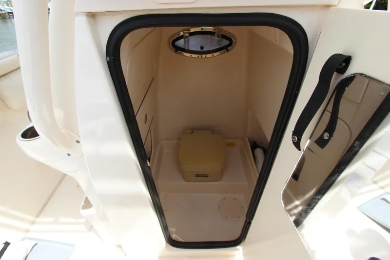 Slide: The Image of 2015 Grady-White 251 Coastal Explorer boat cabin interior with compact toilet. - 33