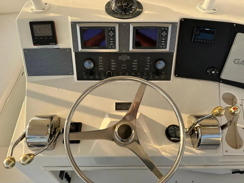 Slide: The Image of Control panel of 1996 Viking 43 Convertible Sportfish with steering wheel and navigation instruments. - 13