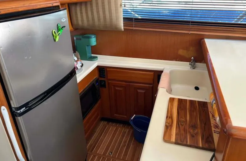 Slide: The Image of 1996 Viking 43 Convertible Sportfish kitchen with fridge, sink, and wooden countertop. - 19