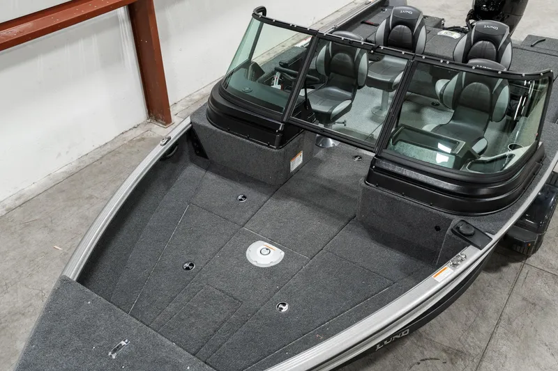 Slide: The Image of 2025 Lund 1875 Impact boat with spacious seating and modern design in a showroom. - 10