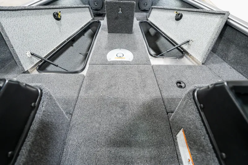 Slide: The Image of 2025 Lund 1875 Impact boat interior with open storage compartments and carpeted flooring. - 19