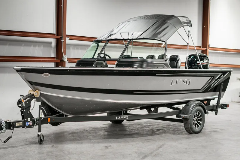 Slide: The Image of 2025 Lund 1875 Impact boat on trailer in indoor setting. - 3