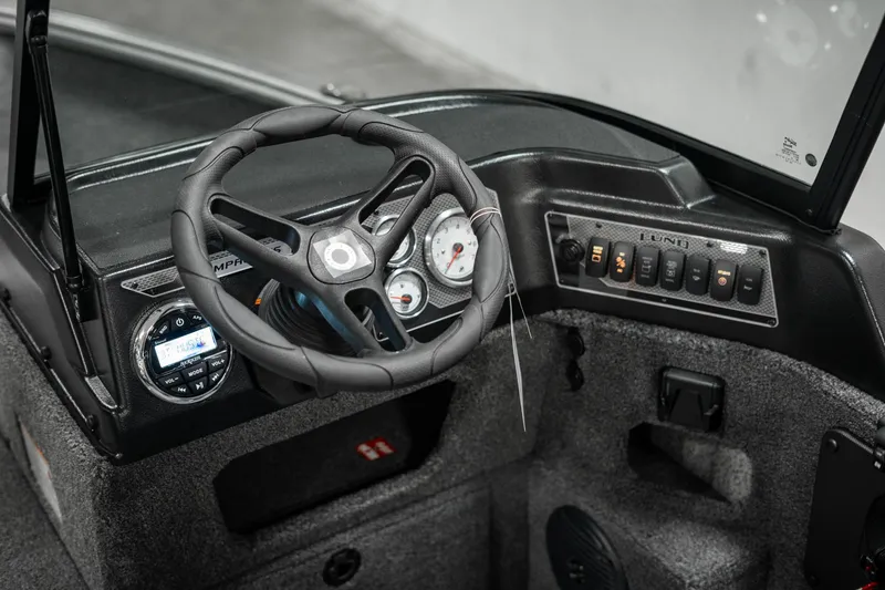 Slide: The Image of 2025 Lund 1875 Impact boat dashboard with steering wheel and control panel. - 36
