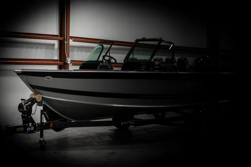 Slide: The Image of 2025 Lund 1875 Impact boat in a dimly lit garage. - 4