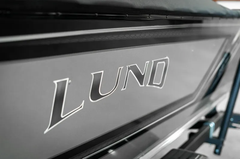 Slide: The Image of Close-up of 2025 Lund 1875 Impact boat logo on sleek black surface. - 48