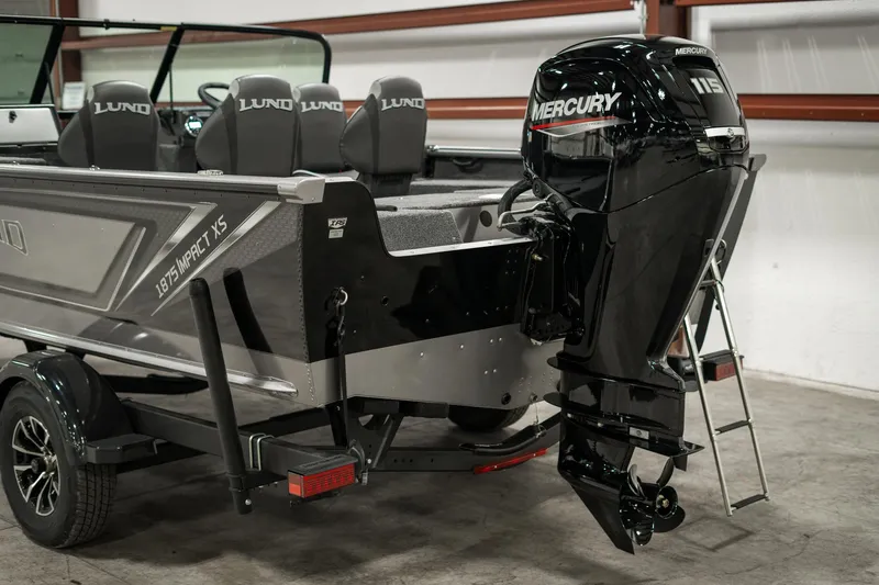 Slide: The Image of 2025 Lund 1875 Impact boat with Mercury outboard motor in a garage. - 49