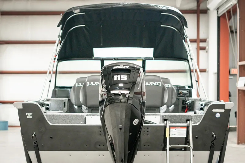 Slide: The Image of 2025 Lund 1875 Impact boat with Mercury 115 engine in a warehouse setting. - 7